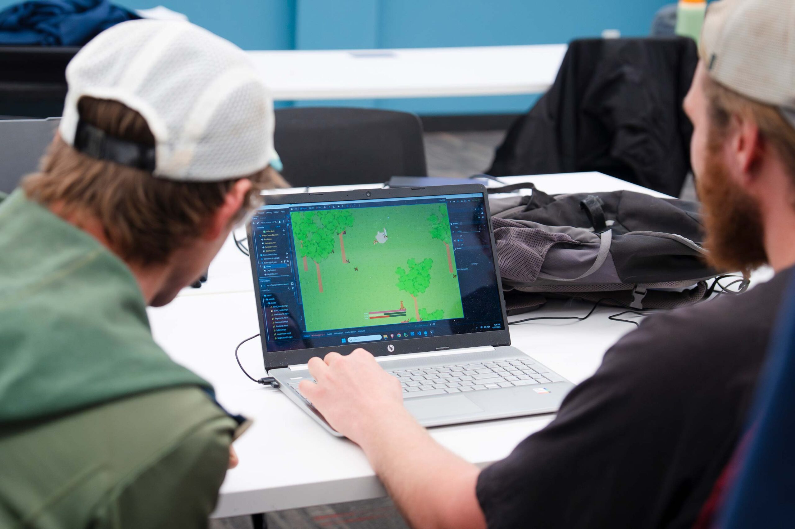A student shows CS professor around the computer game he built.