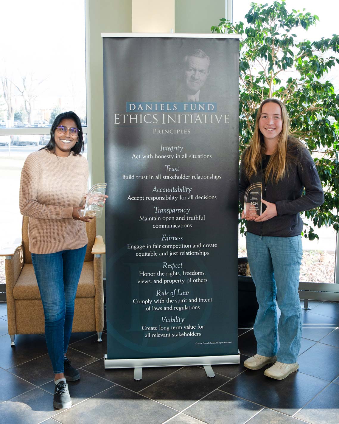 Two students hold awards from the Daniel's Ethics Competition.