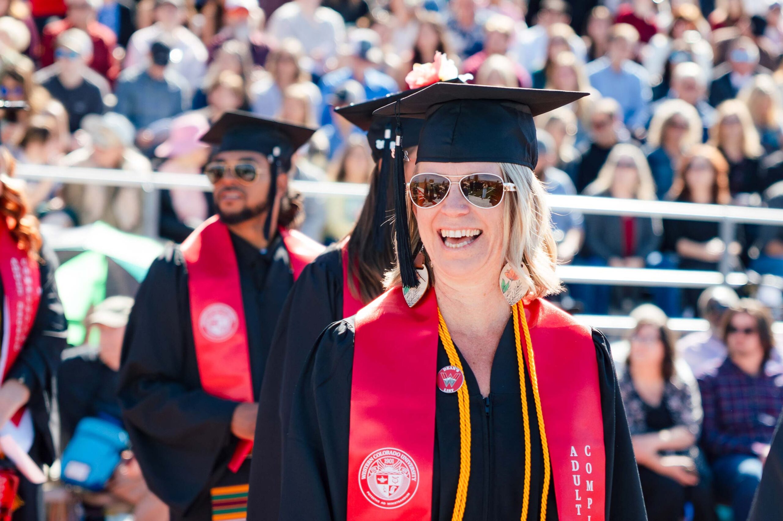 An Adult Degree Completion graduate smiles as she finds her seat.