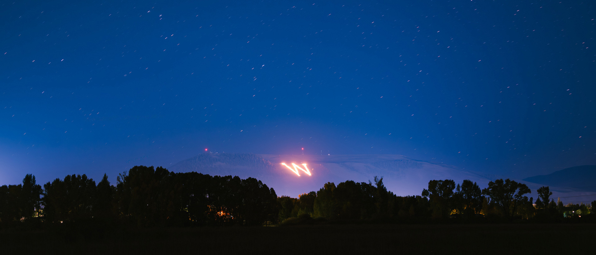 Seen from Van Tuyl Ranch, the collegiate "W" on Tenderfoot Mountain is lit on fire during the first night of Homecoming weekend.