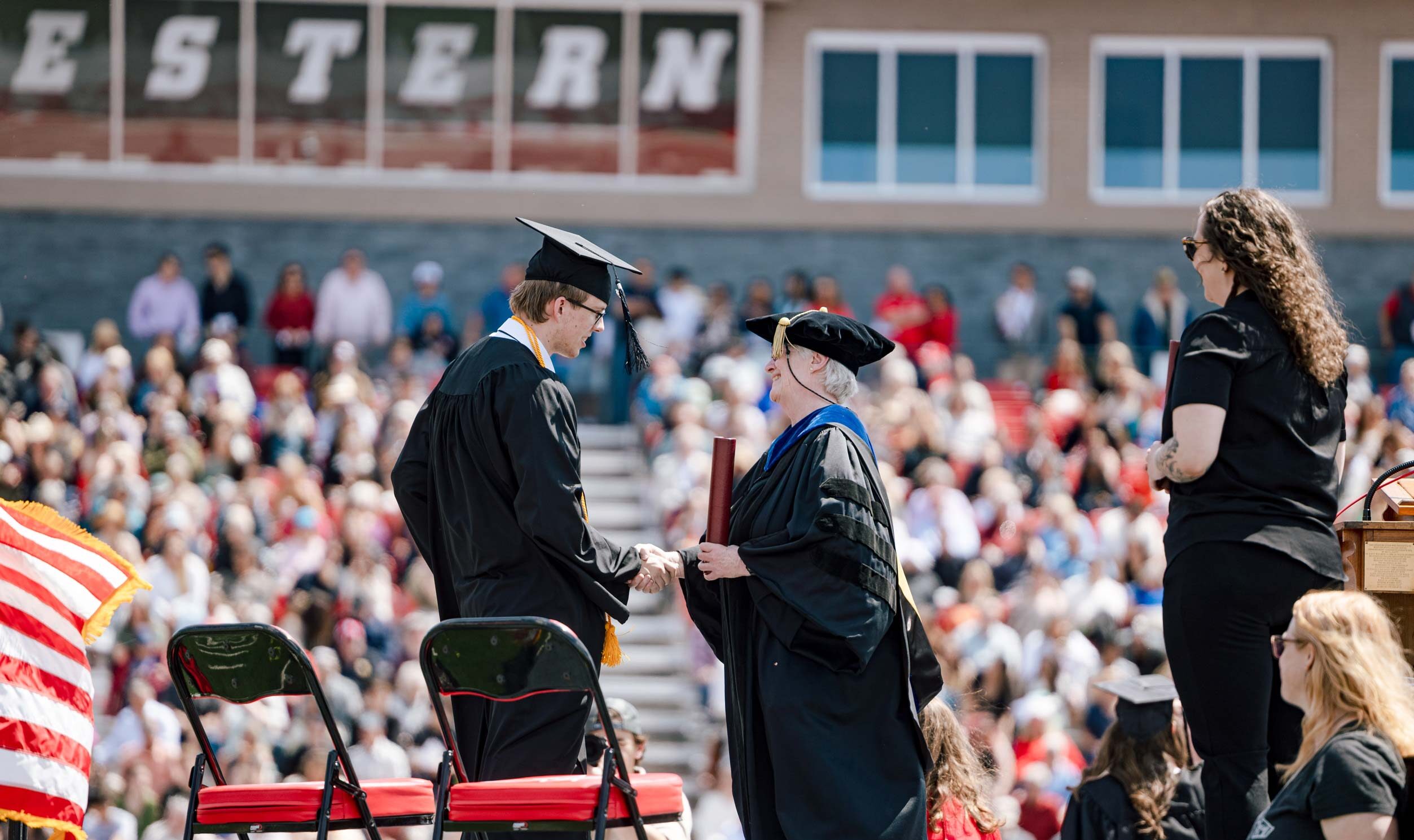 A graduate receives his diploma from Jess Young.