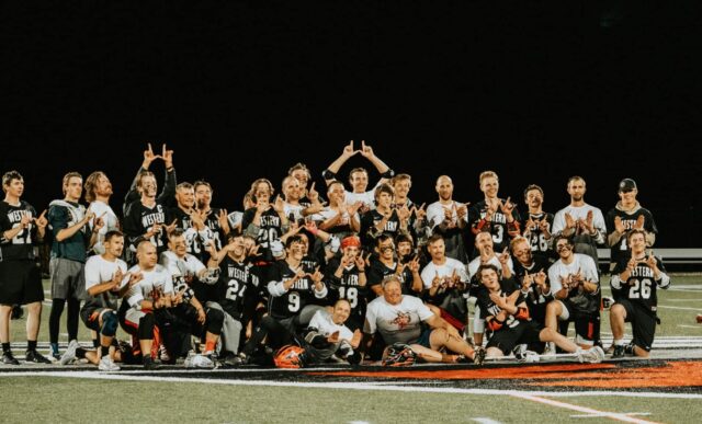 Group photo of the lacrosse team at night.